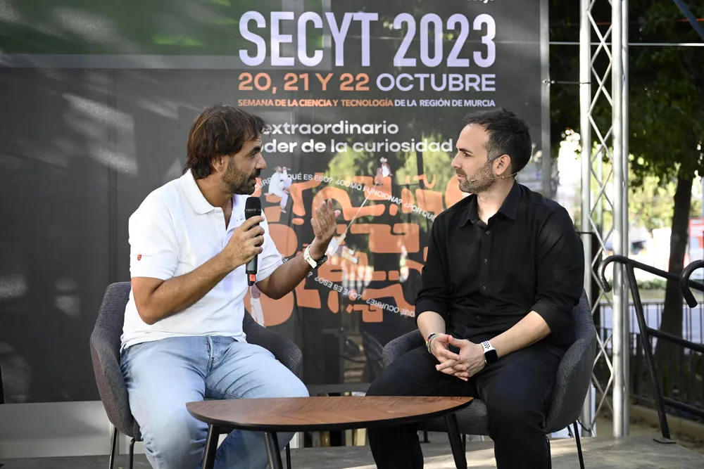Santi García Cremades conversando con un invitado en el escenario de la Semana de la Ciencia y la Tecnología